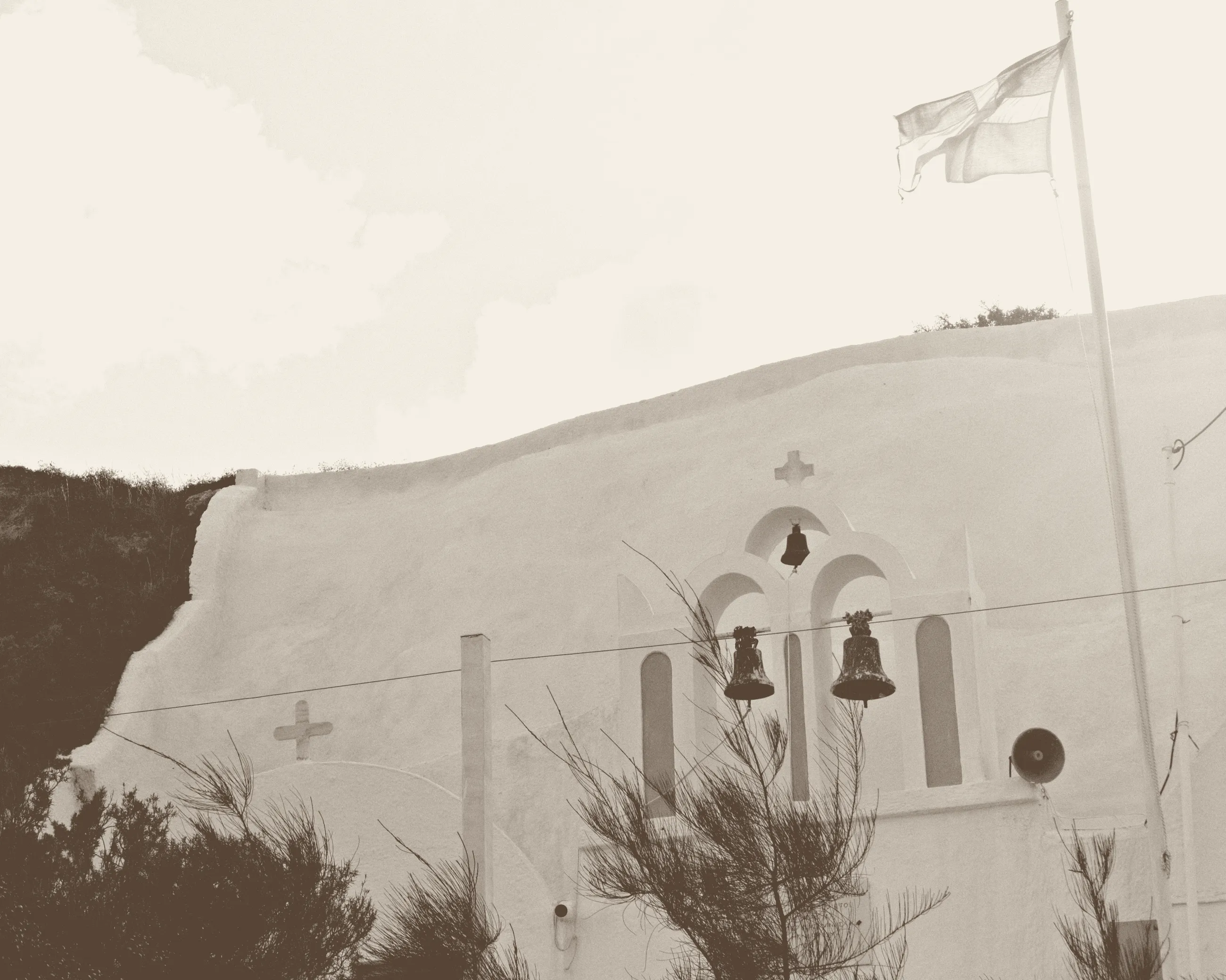 The bell gable of Agios Prokopios, Vothonas, with its flag above the wall